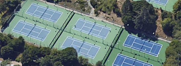 Aerial view of the pickleball courts at La Madrona Athletic Club in Santa Cruz, surrounded by trees and greenery.