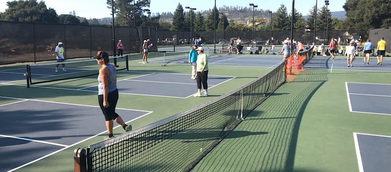 Players enjoying pickleball games at Skypark in Scotts Valley, with multiple courts and a scenic backdrop.