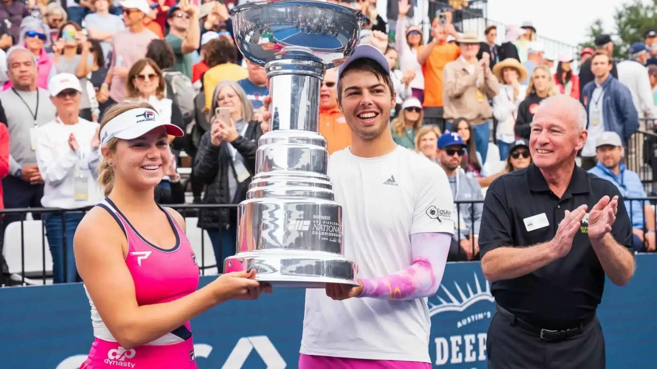 Mixed doubles champions celebrating a victory, showcasing successful pickleball strategies for doubles at a professional tournament.